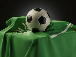 football resting on top of a saudi arabia flag on a table
