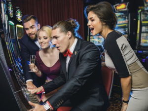 friends playing a slot machine together social gambling