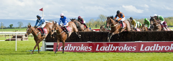irish grand national horses jumping a fence