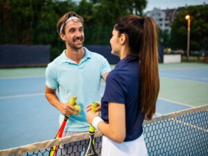 man and woman playing tennis together