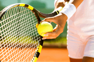 tennis player serving close up of bat and ball