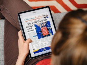 woman reading national newspaper online on a tablet